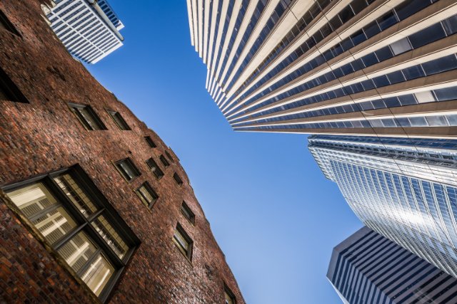 A historic brick building alongside modern city towers